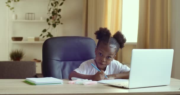 Jolie fille de l'âge de l'école primaire de race mixte ethnie étudier seul dessin sur papier. Fille africaine faisant des devoirs écriture exercice enseignement à distance avec ordinateur portable. Concept d'éducation à domicile des enfants — Video