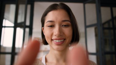 Web kamerası bakış açısı POV İspanyol kadın gülümseme gen z kullanıcı kız etkilenen kadın parmaklar cep telefonu yazma mesaj ekranı dokunmatik akıllı telefon görüntüleme online sohbet aleti bağımlısı evde