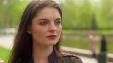 Beyaz Avrupalı kadın gülümsüyor elinde çiçek kokan papatya kokusuyla kameraya bakıyor papatya çiçekli kadın papatya portresi kadın iş kadını şehir kızı açık hava parkı doğal çiçek bitkisi