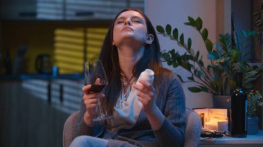 Zor bir seçim olduğunu düşünen üzgün bir kadın şarap ya da hap içer antibiyotik içen hasta bir kız hayal kırıklığına uğramış beyaz bir kız evde ağrı kesici içiyor.