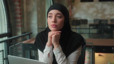 Arap iş kadını, üzgün, hayal kırıklığına uğramış Müslüman kadın, tesettürlü iş kadını, iş kadını ve dizüstü bilgisayar işvereni sorunların çözümünü melankolik, düşünceli ve derin düşünceli düşünüyor.