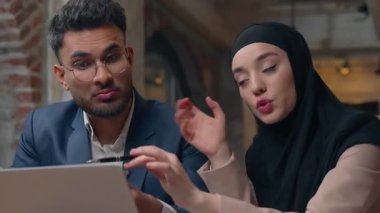 Müslüman iş adamları iki yönetici kadın dizüstü bilgisayarla projeyi tartıştılar. Hintli iş adamlarıyla tesettüre giren İslamcı iş kadını beyin fırtınası yaptılar.