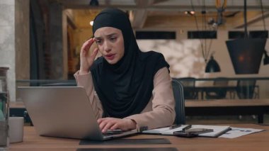 Ofis çalışanı, dizüstü bilgisayar yazılımında kadınlara yardım ediyor. İki Arap iş adamı, bilgisayar hatasıyla tesettüre girmiş Müslüman iş kadınına yardım ediyor.