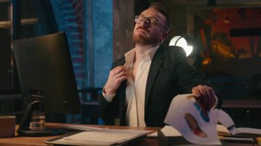 Çok çalışan terli iş adamı, kafkasyalı kağıtlarla üflüyor. Erkek müdür, boğucu bir sıcak akşam ofisi karanlık gece fazla mesaisi, çalışan yönetici, bozuk klima yüzünden acı çekiyor.