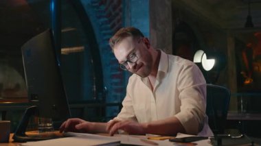 Mutlu iş adamı gece bilgisayarını kapatıyor. Son teslim tarihini dolduruyor. İşini bilgisayar başında başarılı bir iş adamı olarak bitiriyor.