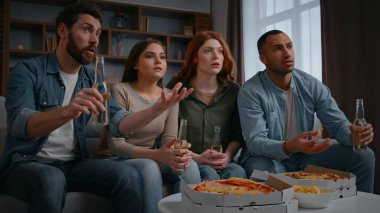 Çok ırklı dört arkadaş TV 'de spor programı izliyorlar. En sevilen spor takımını destekliyorlar. Kaybettikleri için üzgünler.