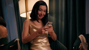 Asyalı Japon kadın Japon bayan Koreli internetten cep telefonu mesajı alıyor. Mutlu, kaygısız, güler yüzlü, akıllı telefon uygulaması yazıp internette cep telefonu sohbeti yapıyor.