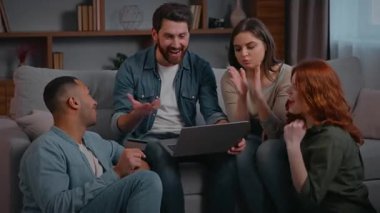 Neşeli, çok ırklı dört arkadaş alışveriş laptopunu kutluyor. Evet, alkışlıyorlar. Başarılı bir jest.