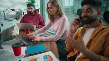 Dört çok ırklı iş arkadaşı, gayri resmi ofis çalışanı kadın ekip elemanı. Çok uluslu Afrika Kafkasyalı iş kadını ve dizüstü bilgisayarları olan Hintli adam telefonda konuşuyor.