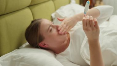 Kafkasyalı kadın, vücut ısısını ölçüyor, baş ağrısı çekiyor, kötü hissediyor, sağlık sorunları yaşıyor, virüs salgını var, hasta 19 hasta kadın yatakta yatıyor, koronavirüs belirtilerini gösteriyor.