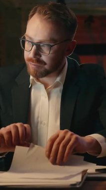 Akşamları birden fazla iş adamının karanlık ofiste telefon görüşmesi yapması, kağıt incelemesi, beyaz iş adamı erkek girişimci lideri geceleri belgelerle uğraşması, akıllı telefonlara cevap vermesi.