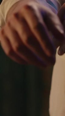 Tanınmayan iş adamı kollarını sıvayıp yaka gömleğini düzeltiyor. Akşam işi bitiyor. İş günü ofiste tekstil stili, şık iş adamı kıyafetleri hazırlıyor.