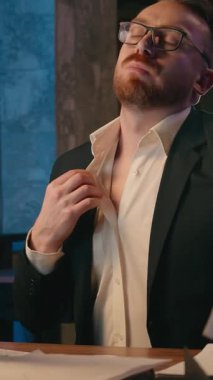 Çok çalışan terli iş adamı, kafkasyalı kağıtlarla üflüyor. Erkek müdür, boğucu bir sıcak akşam ofisi karanlık gece fazla mesaisi, çalışan yönetici, bozuk klima yüzünden acı çekiyor.