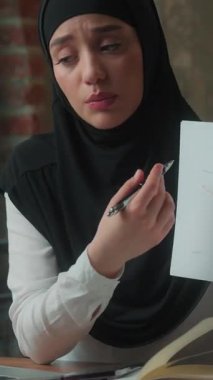 Başörtülü Müslüman iş kadını bilgisayarlı video konferansında kötü sonuç gösteren istatistikleri gösteriyor. Hindu İslami kadın işkadını üzgün Hindu iş kadını çevrimiçi konferans belgelerini tutuyor.