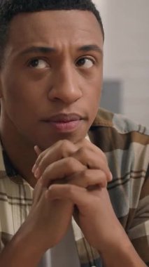 Yaratıcı düşünen Afro-Amerikan bir adam, fikir üreten, derin kararlar veren, şüpheci, dalgın, erkek, oturma odasında ipotekli ev kredisi ile ilgili endişelenen, kapalı alanda düşünceli, düşünceli, düşünceli, düşünceli bir adam.