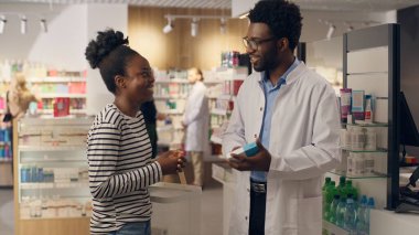 Eczacı, eczacı tavsiyesine yardımcı olur. Eczane sağlık hizmetleri danışmanlığında vitamin satın alır. Afro-Amerikan erkek kadın tavsiyesi.