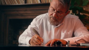 Kendinden emin, yaşlı, beyaz, olgun bir erkek kamera önünde el ele tutuşmuş ofis işadamı yakışıklı, yaşlı çalışan portresi liderinin içindeki iş adamına bakıyor.