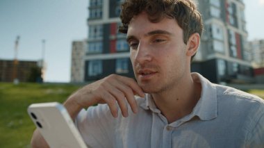 Beyaz adam ekrandaki cep telefonuna bakıyor akıllı telefon teknolojisi internetteki sohbet mesajları sosyal ağlar erkek işadamı iş adamı şehir içi iletişimi zımbırtısı.