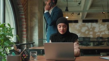 Müslüman iş adamları, ofis kadınlarının tesettüre girip dizüstü bilgisayarlarını yazarken sinirli Hintli adam, cep telefonu araması liderinin sinir bozucu, bilgisayar işi yapan stajyer sekreter bayanı tartışıyor.