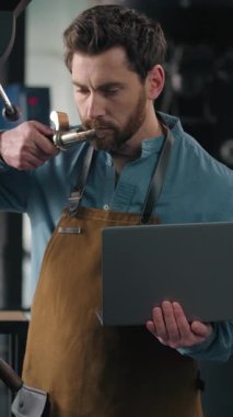 Kafkasyalı bir adam kavrulmuş kahve kumaşında çalışıyor. Kızartma makinesini teftiş ediyor. Kafein kokluyor, aroma kokluyor.