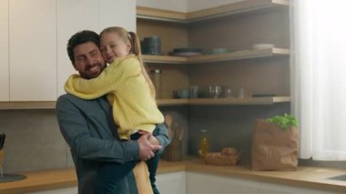 Yetişkin baba baba baba, mutfakta küçük sevimli kızı kucaklıyor mutlu aile kucaklaşması. Çocuk kız ve baba burunlarına dokunur. Ev yemeği velayetinde iyi bir ilişki kurarlar.