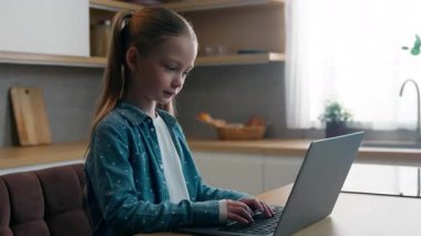 Genç nesil ve modern teknoloji aleti bağımlısı Kafkasyalı kız çocuğu çocuk bilgisayar oyunu yazarken evdeki sosyal medyayı kullanarak uzaktan eğitim öğreniyor.