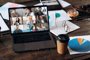Virtual business meeting online. Video conference by laptop. Online business meeting. On the laptop screen that standing on a desk, coworkers who gathered in a video conference to work online clipart