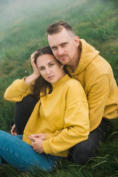 Beautiful Couple Love Identical Yellow Hoodies Sits Hill Grass Hugging — Stock Photo, Image