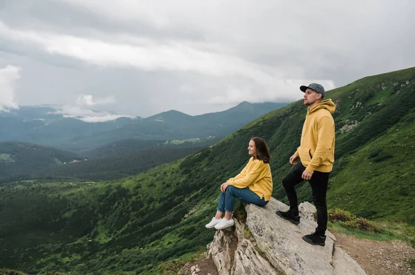 İlham verici bir manzara. Dağlarda aşk. Uçurumun kenarında birbirine aşık mutlu bir çift bu inanılmaz dağ manzarasının tadını çıkarıyor.