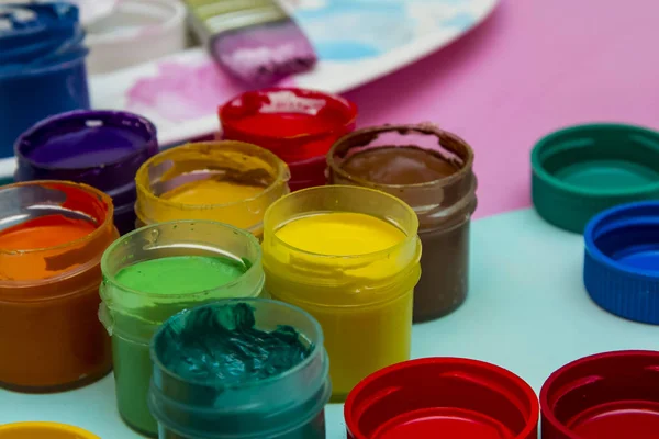 in jars of multi-colored paint for drawing