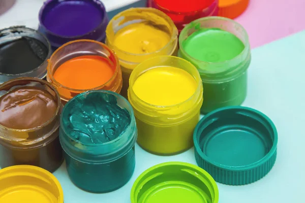 in jars of multi-colored paint for drawing