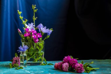 Mavi arka plan ile masaya pembe yonca çiçek