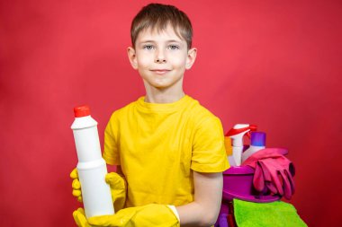 Sarı eldivenli, temizlik malzemeli bir çocuk. 