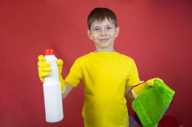 Sarı eldivenli, temizlik malzemeli bir çocuk. 