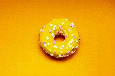 Renkli bir arka planda kremalı ve serpiştirilmiş çörek.