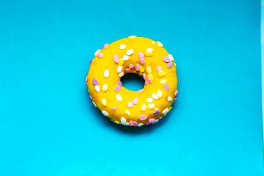 Renkli bir arka planda kremalı ve serpiştirilmiş çörek.