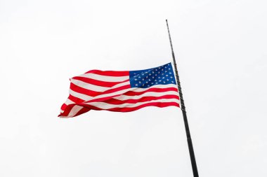 Uçan bir Half-staff karşı gri gökyüzü sallayarak Amerika Birleşik Devletleri bayrağı