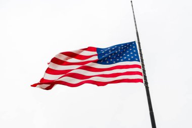 Uçan bir Half-staff karşı gri gökyüzü sallayarak Amerika Birleşik Devletleri bayrağı