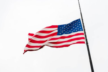 Uçan bir Half-staff karşı gri gökyüzü sallayarak Amerika Birleşik Devletleri bayrağı