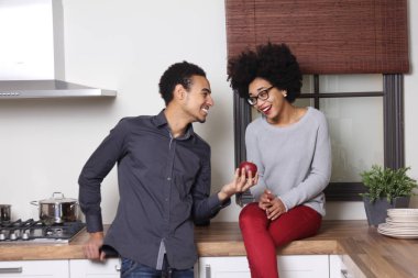 Afro-Amerikan erkek kadın için mutfak üzerinde elma veriyor