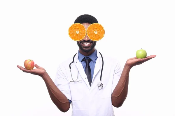 若いアフロ アメリカン マン博士の目とりんごを手にしたオレンジの破片 — ストック写真