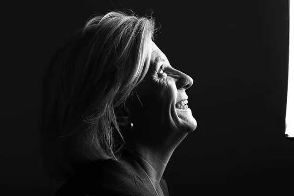 Old caucasian woman is smiling on black and white tone