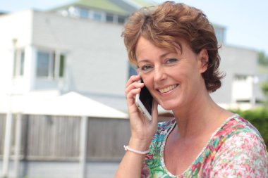 Kadın cep telefonuyla konuşuyor.