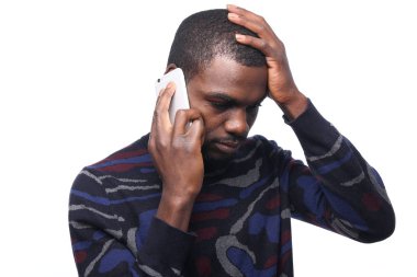 Siyah adam cep telefonuyla konuşuyor.