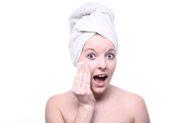 Genç sarışın kız yüzünü temizliyor