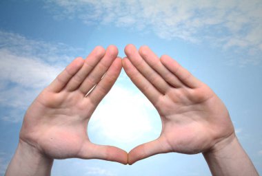 Güneşli gökyüzünde arka plan üzerinde iki el