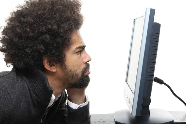 Black man looking on computer screen on white background