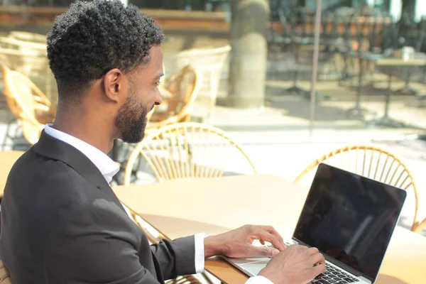 Black businessman is using laptop at cafe