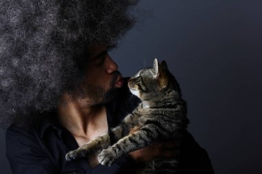 Siyah adam holding kedi elinde