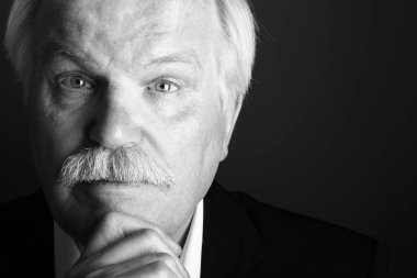 Yaşlı beyaz adam beyaz ve siyah arka plan üzerinde düşünme 